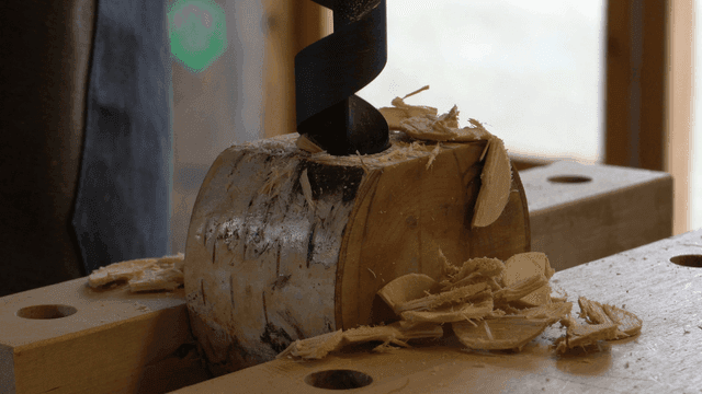 나무에 드릴로 구멍을 뚫는 장면