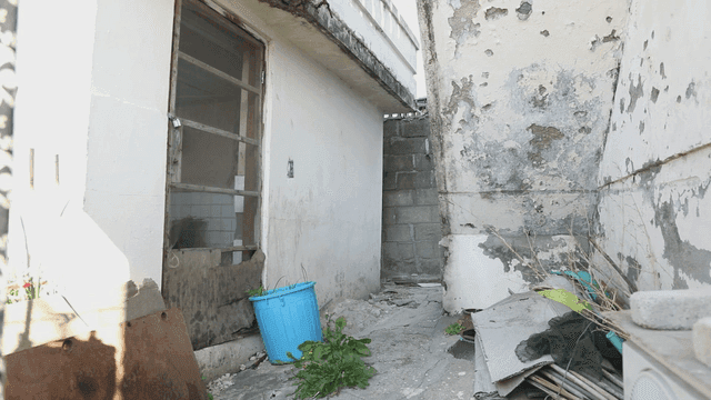 페인트가 벗겨진 벽과 잔해가 있는 오래된 골목