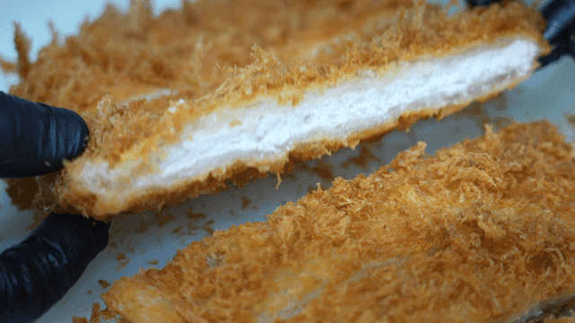 잘 튀겨진 돈까스 단면을 보여주는 장면