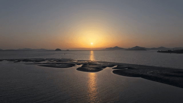 섬이 있는 고요한 바다의 일몰