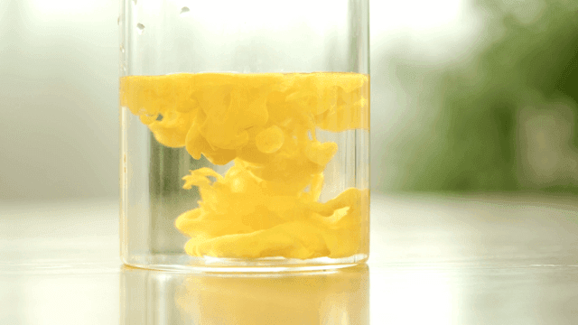 Yellow liquid mixing in a clear container