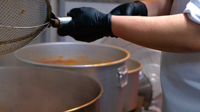 Cooking using a strainer and large pot in the kitchen