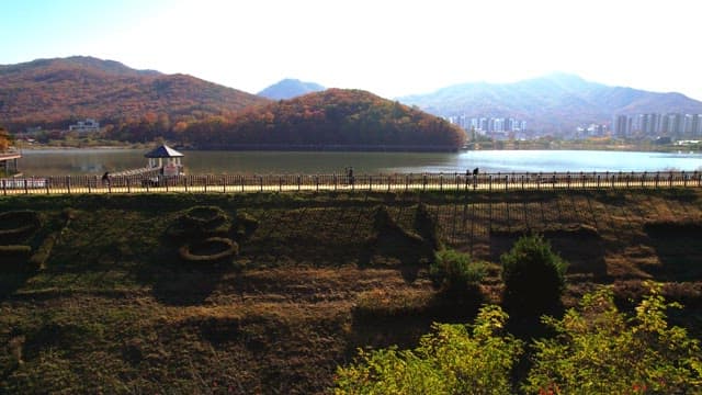 Beautiful Baegunhosu Lake with autumn trees and a view of the walking trail of people