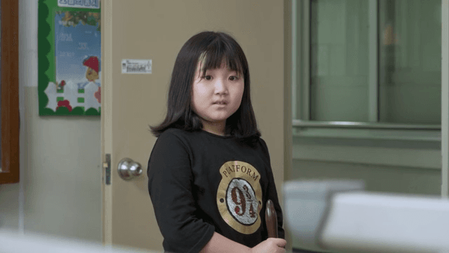 Child talking to someone while cleaning the classroom