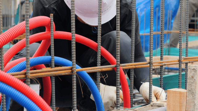 Worker installing cables at a construction site