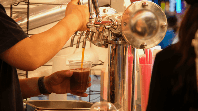 Person pouring beer into plastic cup