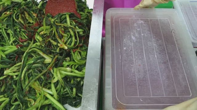 Preparing Kimchi with fresh vegetables and red pepper paste in a kitchen