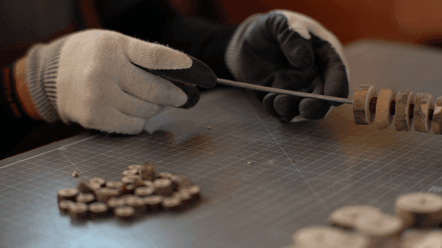 장갑 낀 손이 나무 원반을 배열하는 모습