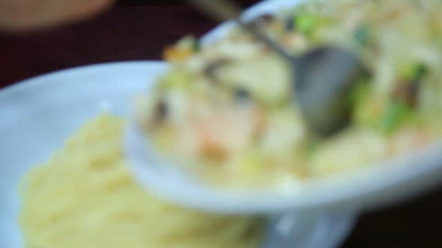 Pouring the jjajang sauce mixed with seafood and vegetables into a bowl of noodles