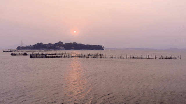 Sunset over a calm sea with distant islands