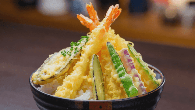 Tempura rice bowl topped with vegetables and fried shrimp