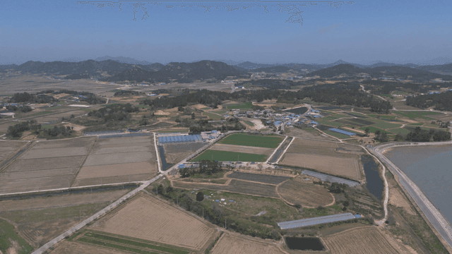Wide farmland with mountains visible in distance.
