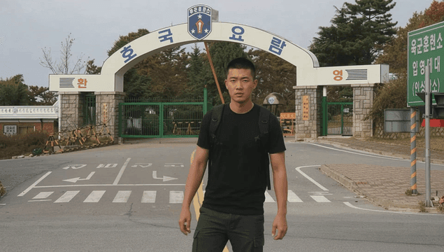 Young man greeting at entrance to army training camp.