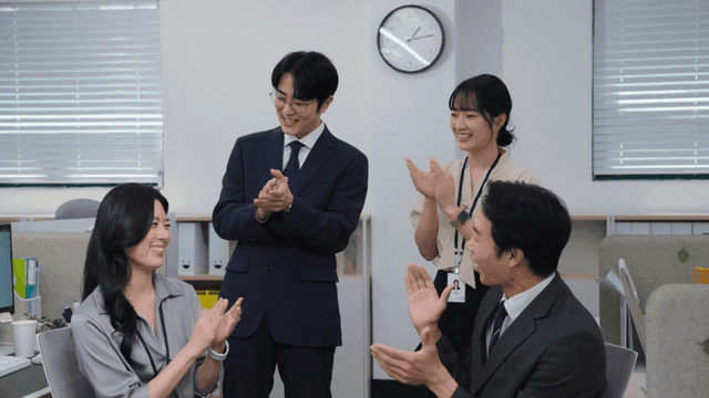 사무실에서 박수 치며 웃는 직원들