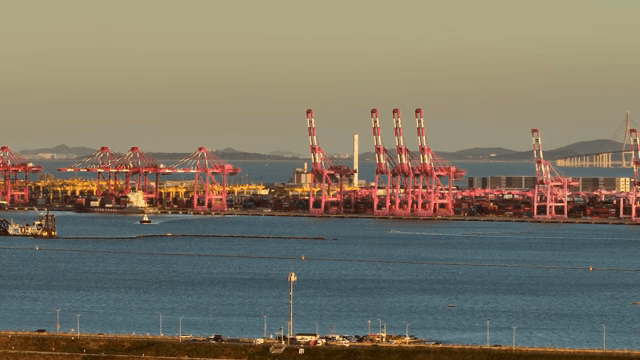 일몰에 바쁜 항구의 화물 크레인