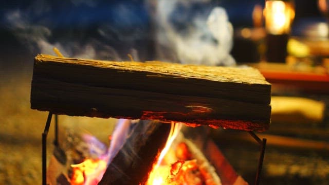 Campfire rising from the wood in the brazier at night