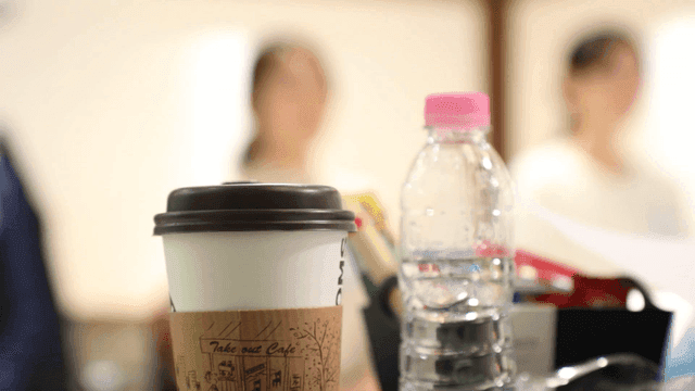 Coffee cup and water bottle on a table