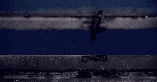 서리가 낀 창문의 걸쇠를 열고 닫는 손