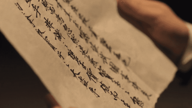 손으로 쓴 문서를 들고 있는 사람