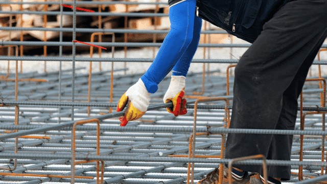건설 현장에서 철근을 조립하는 작업자