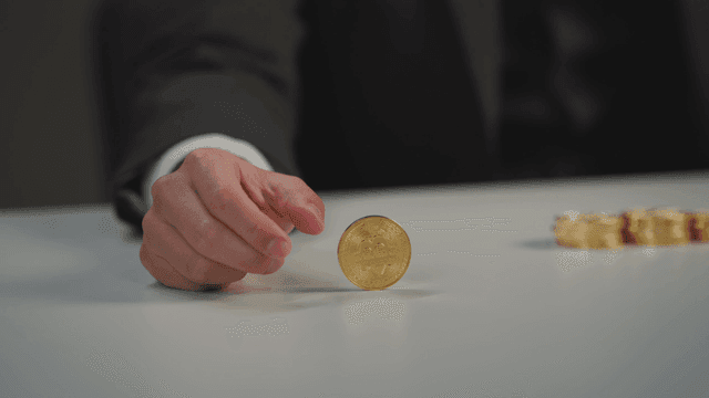 테이블 위에서 비트코인을 굴리는 손