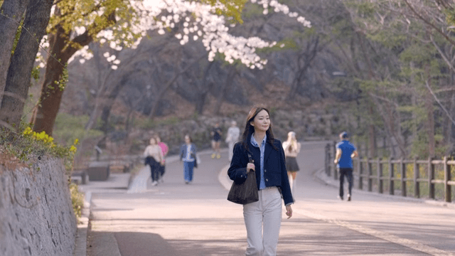벚꽃 나무 아래에서 산책을 하는 여성