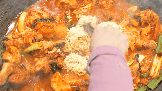 Ramen noodles added to spicy braised chicken