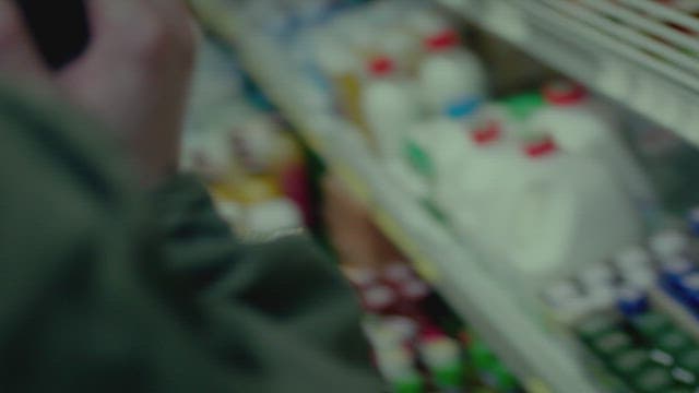 야간 편의점에서 전화 통화를 하며 쇼핑하는 사람