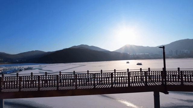 나무 다리가 있는 얼어붙은 호수