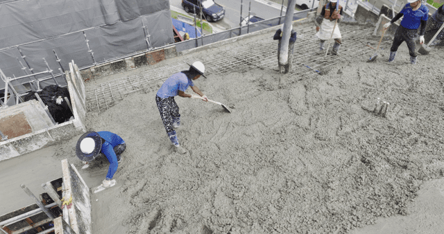 건설 현장에서 콘크리트를 붓는 작업자들