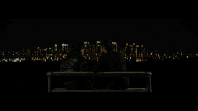 밤에 벤치에 앉아 있는 두 사람