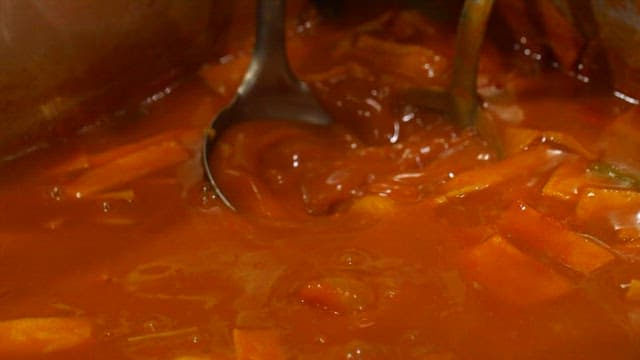 Tteokbokki being served in a bowl