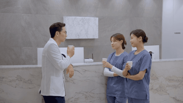 병원 접수 데스크에서 간호사들과 대화하는 의사