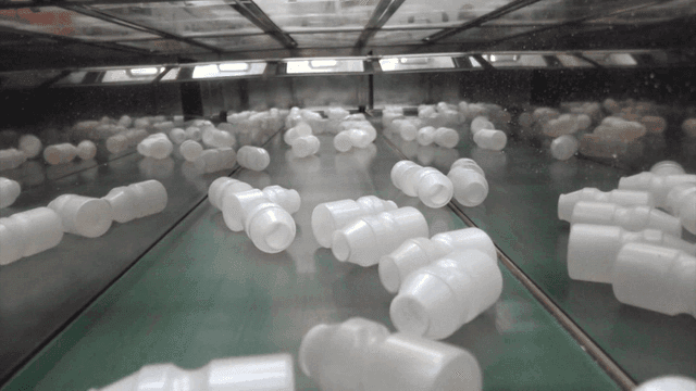 Plastic yogurt bottles on conveyor belt in production line
