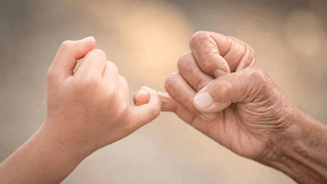 Sight of child's and old person's hands making promise