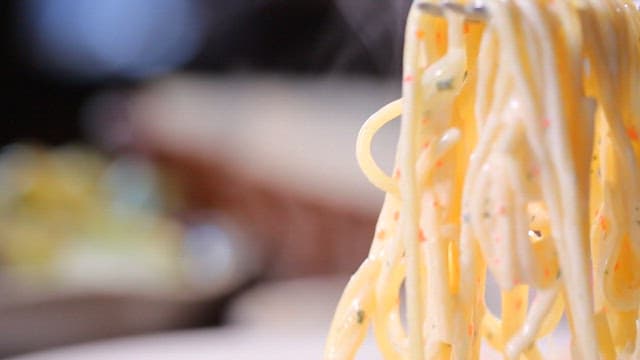 Creamy pasta being lifted with a fork