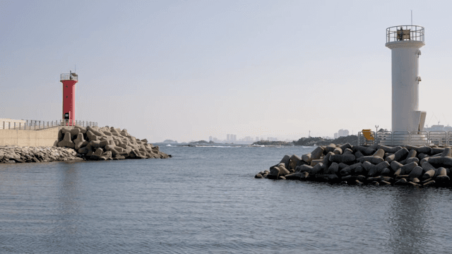 빨간색과 흰색 등대가 있는 잔잔한 바다