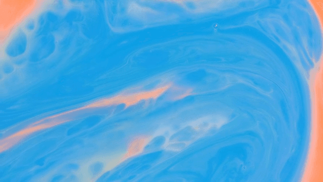 Abstract pattern of red and orange liquids mixing together
