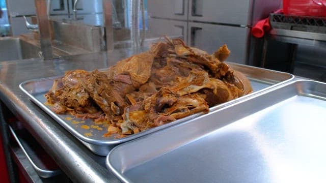 Steamed meat pieces on a metal tray in a kitchen