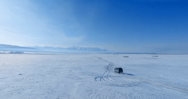 눈 덮인 평원을 가로지르는 차량
