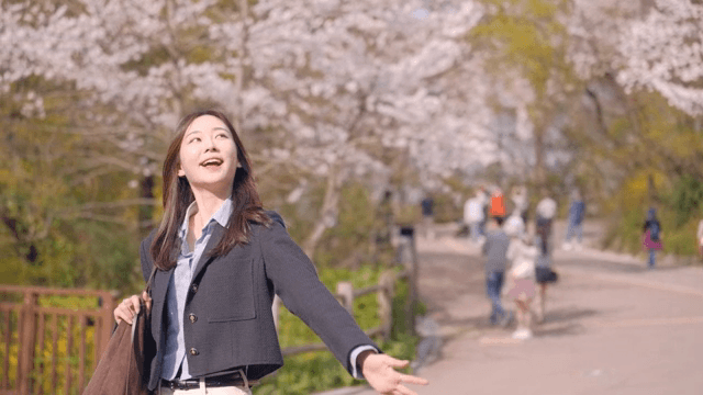 Woman walking through a park and looking at flowers