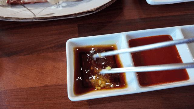 Picture of wasabi being mixed into soy sauce with chopsticks