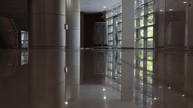 반짝이는 복도 바닥을 청소하는 사람