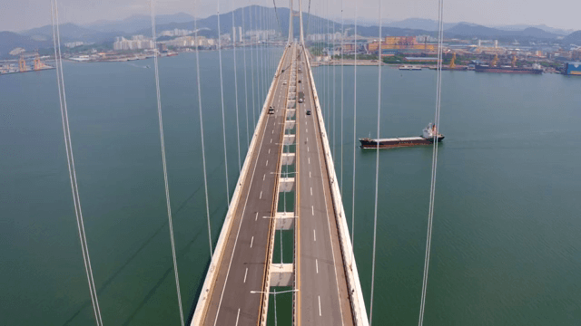 차량이 있는 고요한 바다 위의 긴 다리