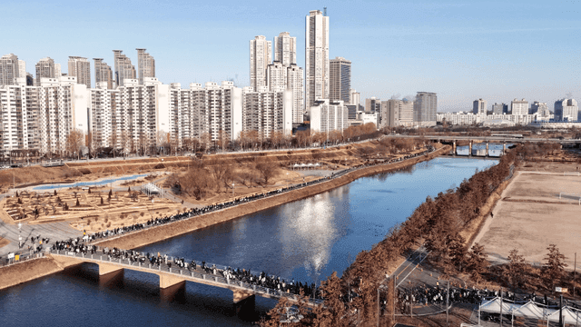 People running in river next to city apartments
