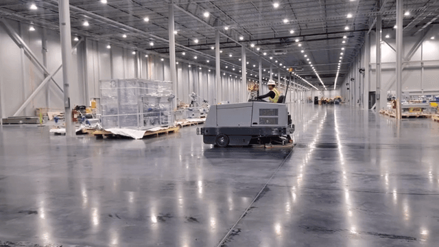Worker operating a floor cleaning machine