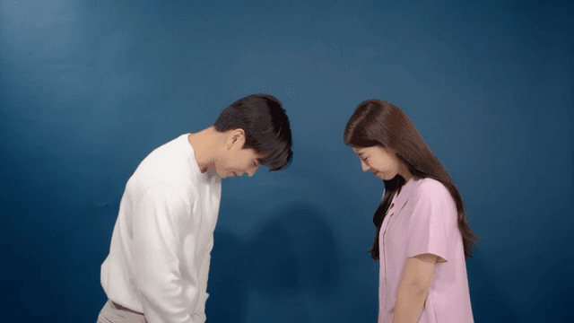 방에서 두 남녀가 정중하게 고개 숙여 인사하는 모습