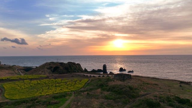 Sunset over a coastal landscape with fields