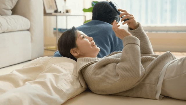 Couple relaxing indoors with a smartphone