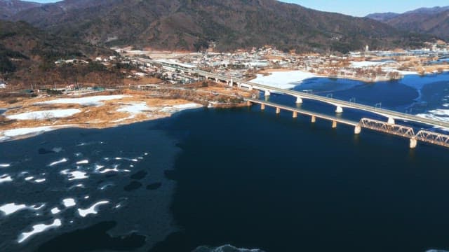 Aerial View of Trains Crossing Snowy Landscape